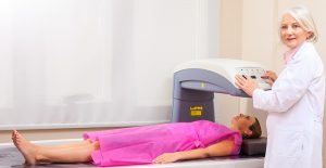 Female patient undergoing x-ray scan with professional assistance.